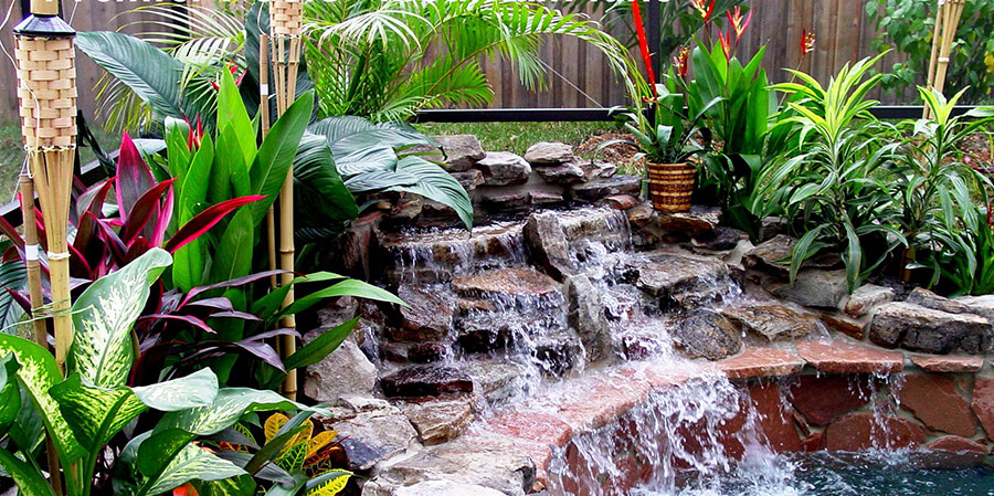 close up image of a flowing natural pool waterfall