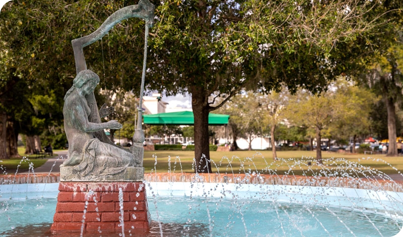Nude Status playing harp in fountain in Winter Park